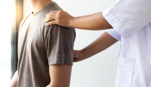 Chiropractor and massage therapist demonstrating different hands-on techniques for back and shoulder care.
